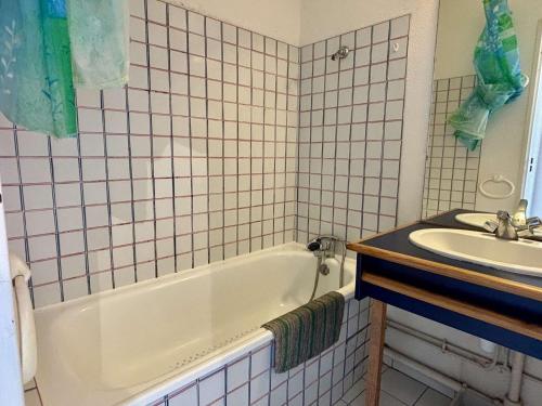 une salle de bain avec une baignoire blanche et un lavabo dans l'établissement Appartement 2P / cabine, proche plage, parking privatif - FR-1-225-59, à Argelès-sur-Mer