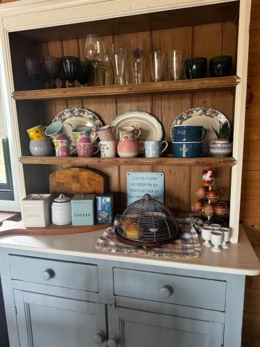 a shelf full of dishes and bowls on a table at Shabby Chic Barn in Galway
