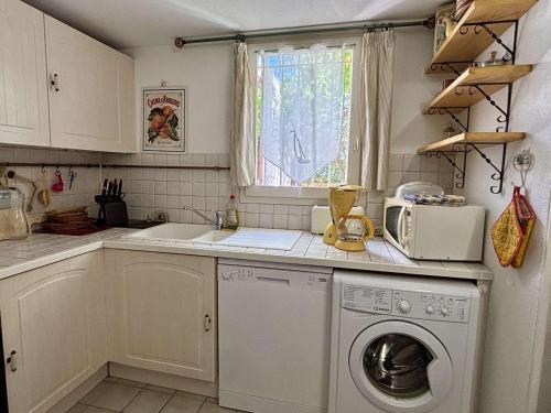 une cuisine avec une machine à laver et une fenêtre dans l'établissement Maison avec Mezzanine: Confort, Terrasse & Proximité Plage à Argelès-sur-Mer - FR-1-225-42, à Argelès-sur-Mer