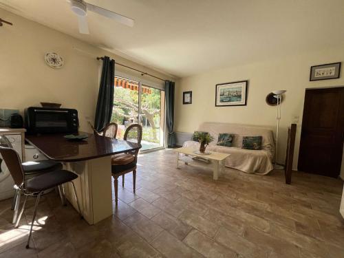 un salon avec une table, des chaises et un canapé dans l'établissement Appartement cozy 2 pièces avec jardin, climatisation et équipements complets - Le Lavandou - FR-1-308-115, au Lavandou
