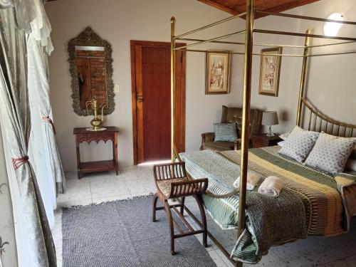 una camera con letto a baldacchino e sedia di Corner Kort and Allenby a Parys