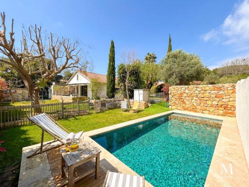 - une piscine avec une chaise et une table dans la cour dans l'établissement Maison d'exception à Sanary proche de la plage, à Sanary-sur-Mer