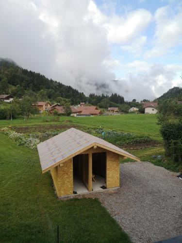 une petite structure en bois dans un champ d'herbe dans l'établissement petit gîte des Marolais, à Mont-Saxonnex
