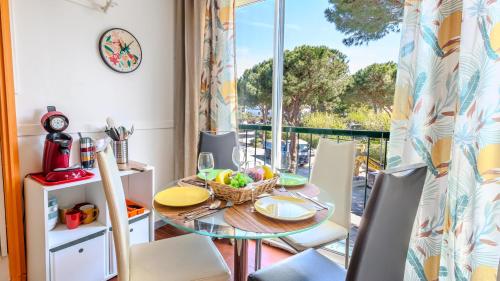 une salle à manger avec une table et des chaises et un balcon dans l'établissement Apaloosa - Parking Wifi Plage TOP PROS SERVICES, à La Grande Motte