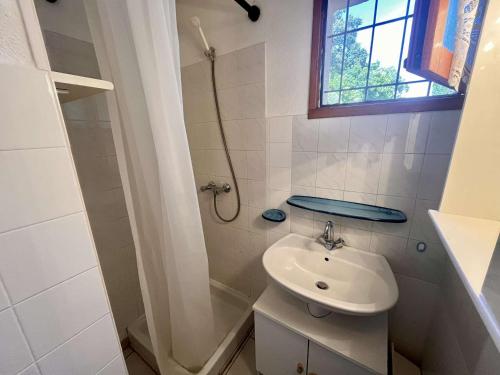 une salle de bain blanche avec un lavabo et une douche dans l'établissement Charmant 2P avec jardin, piscine, parking et navettes gratuites - Cavalaire-sur-Mer - FR-1-226B-196, à Cavalaire-sur-Mer