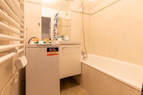 une salle de bain avec un lavabo et une baignoire dans l'établissement 14-Le T2 de Shirley, à Montévrain
