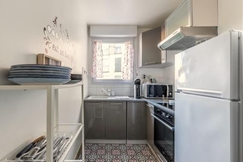 La cuisine blanche est équipée d'un réfrigérateur et d'un évier. dans l'établissement 14-Le T2 de Shirley, à Montévrain