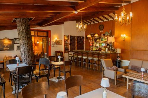 a restaurant with tables and chairs and a bar at New Helvetia Historic Hotel in Platres