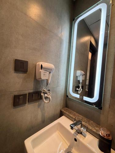a bathroom with a sink and a mirror at Loft Inn Supernova Noida in New Delhi