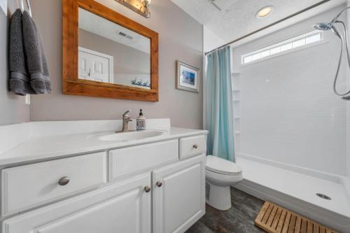 a bathroom with a sink and a toilet and a mirror at Sea Drift 102 by Carolina Beach Realty in Carolina Beach