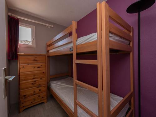 Cette chambre dispose de lits superposés avec 2 lits superposés et une commode. dans l'établissement Appartement T2 avec terrasse, piscine et parking, proche plage - FR-1-803-93, au Lavandou