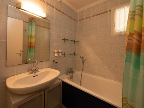 une salle de bain avec un lavabo, un miroir et une baignoire dans l'établissement Appartement T2 avec terrasse, piscine et parking, proche plage - FR-1-803-93, au Lavandou