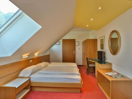 a attic bedroom with a bed and a desk at Hotel Sparerhof in Vilpiano