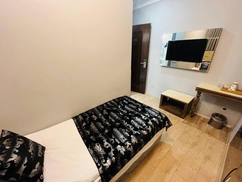 a bedroom with a bed with a black and white blanket at City Center Hotel Taksim İstanbul in Istanbul