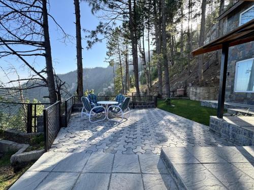a patio with two chairs and a table on a house at Haven Lodge Khaira Gali - Pine Ridge Residences #7 in Khaira Gali