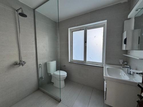a bathroom with a toilet and a sink and a window at Haven Lodge Khaira Gali - Pine Ridge Residences #7 in Khaira Gali