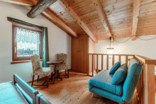 a living room with a blue couch and a table at Ca' del Primo by Quokka 360 - A studio nestled in nature in Bidogno