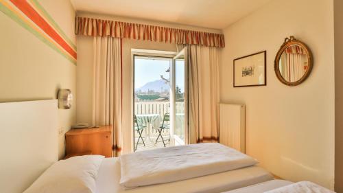 a bedroom with a bed and a view of a balcony at Hotel Sparerhof in Vilpiano