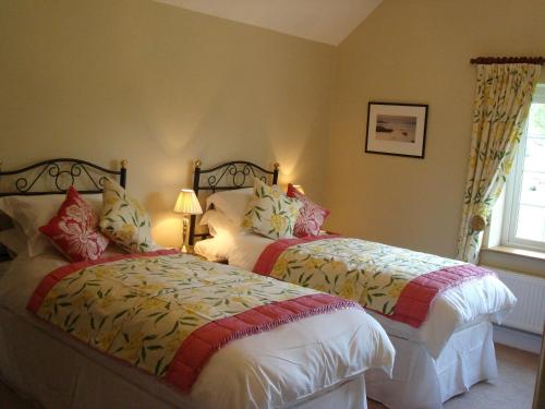 a bedroom with two beds and a window at The Paddock in Haverfordwest