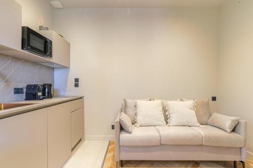 un salon avec un canapé dans une cuisine dans l'établissement Appartement moderne et confortable , Ecully, à Écully