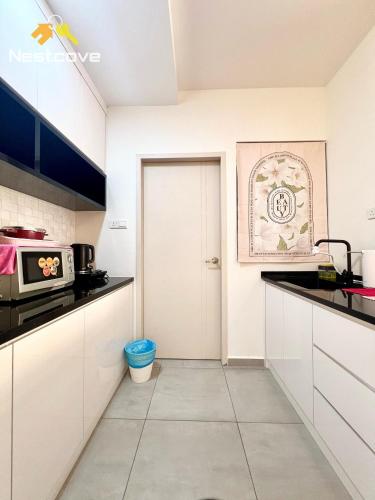 a kitchen with white cabinets and a door at The Quartz Residence & Suites Infinity Pool By Nestcove in Melaka