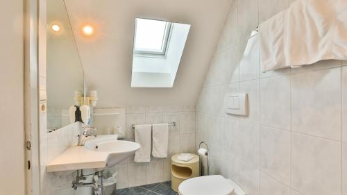 a bathroom with a sink and a toilet and a mirror at Hotel Sparerhof in Vilpiano