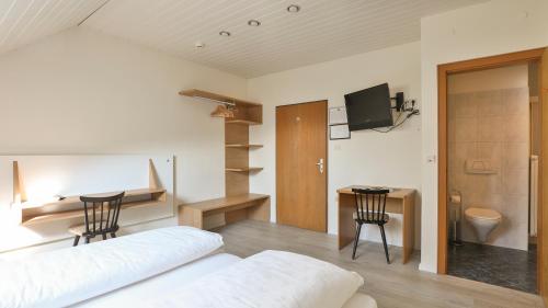 a bedroom with a bed and a desk and a table at Hotel Sparerhof in Vilpiano
