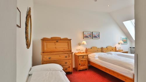 a bedroom with two beds and a wooden dresser at Hotel Sparerhof in Vilpiano
