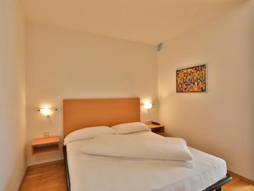 a bedroom with a white bed with two pillows at Hotel Sparerhof in Vilpiano