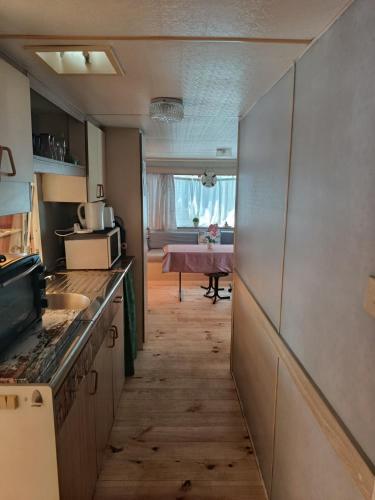 une cuisine avec un couloir menant à une salle à manger dans l'établissement Mobil-home, au Grau-du-Roi