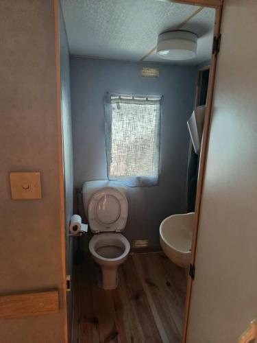 une petite salle de bain avec toilettes et lavabo dans l'établissement Mobil-home, au Grau-du-Roi
