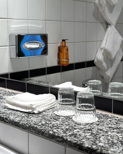 four glasses sitting on a counter in a kitchen at Hotell Bondeheimen in Oslo