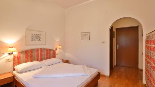 a bedroom with a bed and a hallway with a door at Hotel Sparerhof in Vilpiano