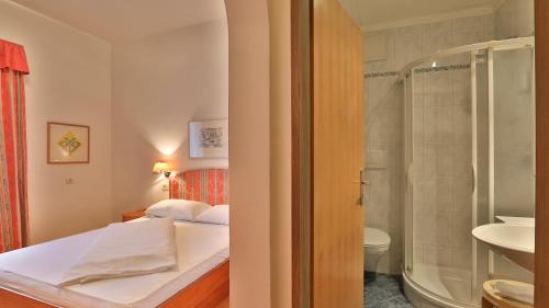 a hotel room with a bed and a shower at Hotel Sparerhof in Vilpiano