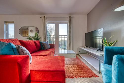 a living room with a red couch and a flat screen tv at Peaceful 2-Bed in Sutton Coldfield, Near Parks in Sutton Coldfield