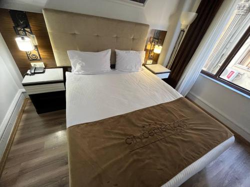 a large bed in a room with two windows at City Center Hotel Taksim İstanbul in Istanbul