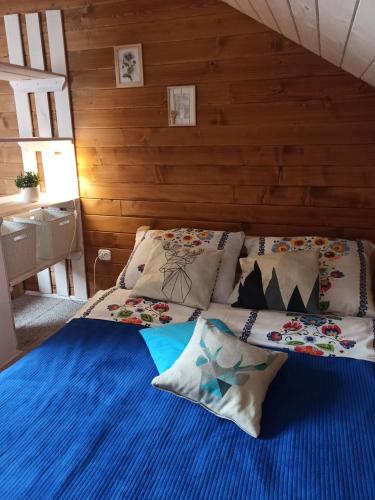 a bedroom with a bed with blue sheets and pillows at Rodzinny zakątek - Noclegi w Bieszczadach - jacuzzi in Myczkowce