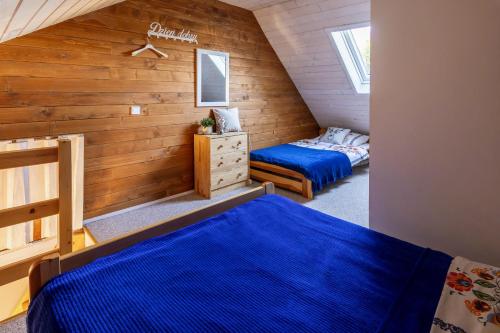 two beds in a room with wooden walls at Rodzinny zakątek - Noclegi w Bieszczadach - jacuzzi in Myczkowce