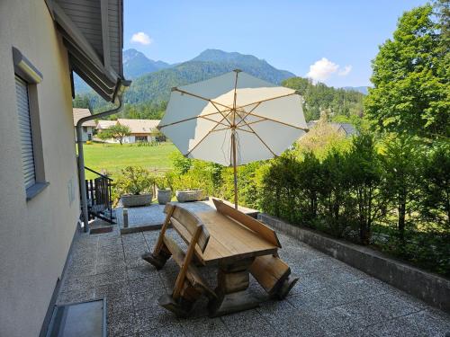 a wooden table with an umbrella on a patio at Apartment Iris in Bohinj