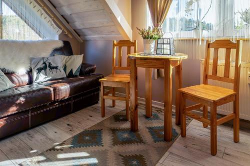 a living room with a couch and a table and chairs at Rodzinny zakątek - Noclegi w Bieszczadach - jacuzzi in Myczkowce