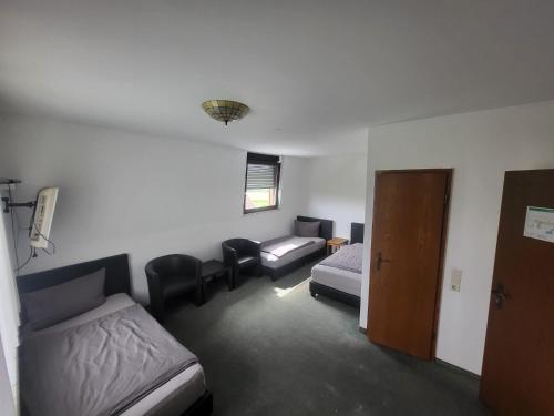 een kamer met een bed en een bed en een bank bij Pension Alex in Bielefeld