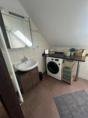 ein Badezimmer mit Waschbecken und Waschmaschine in der Unterkunft Ferienwohnungen AugenBlick 2 Naumburg in Naumburg
