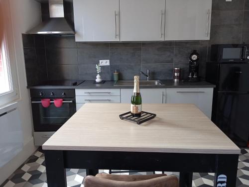 - une cuisine avec une table et une bouteille de vin dans l'établissement la loge sparnacienne, à Épernay