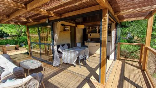 a wooden deck with a table and a kitchen at Lodge premium Pique poque in Aspet