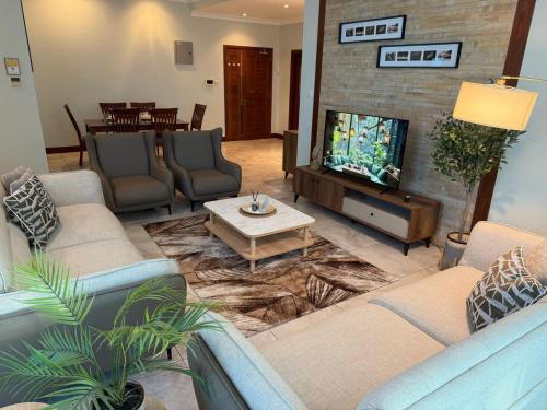 a living room with couches and a flat screen tv at Fairview Luxury Apartments in Dar es Salaam