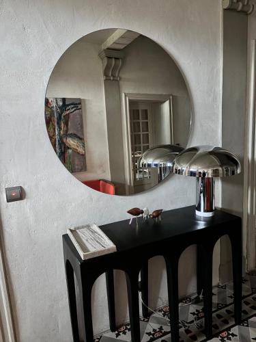 - une table dans une pièce avec un miroir dans l'établissement Idéal festival d Avignon magnifique Mas avec piscine et jacuzzi, à Althen-des-Paluds