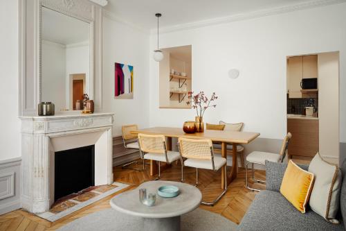 un salon avec une table et une cheminée dans l'établissement Beauquartier - Champs-Elysées, à Paris