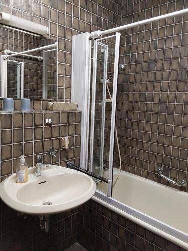 a bathroom with a sink and a tub and a mirror at Ferienwohnung Samerhof Christ in Aschau im Chiemgau