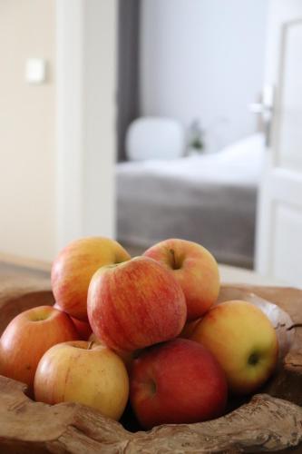 a pile of apples in a bowl on a table at Villa am Schwanenteich in Spremberg