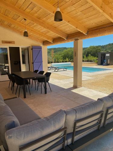 un patio avec une table et des chaises et une piscine dans l'établissement Paradis du Sud, à Salazac